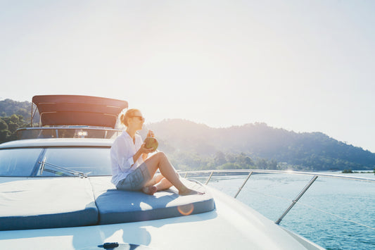 Woman sitting on the front of a boat in the sun