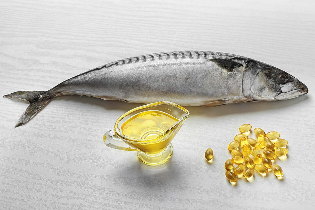 A fish on a table next to fish oil in a measuring cup and pills.